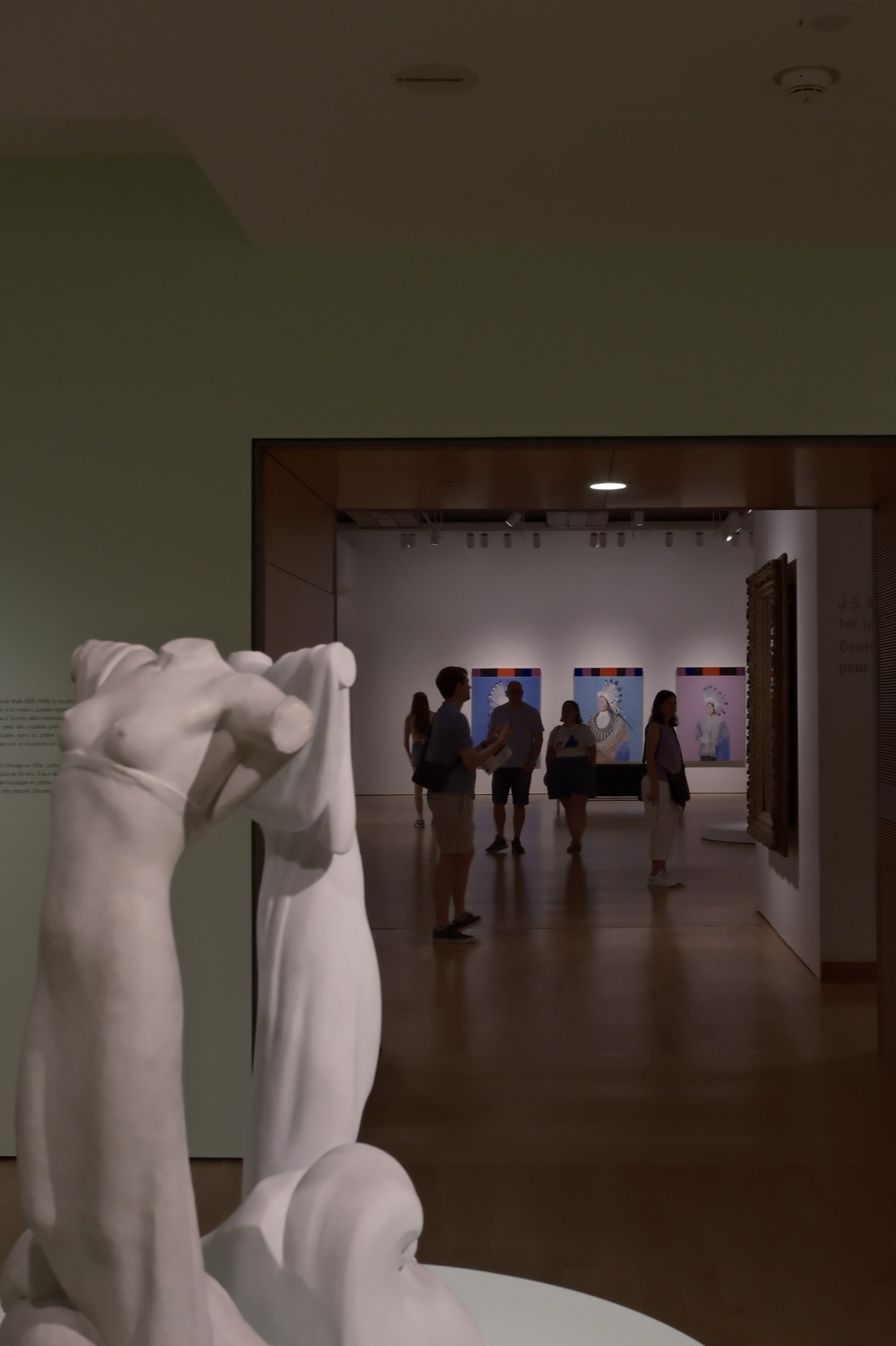A marble torso by the doorway, a bright gallery beyond