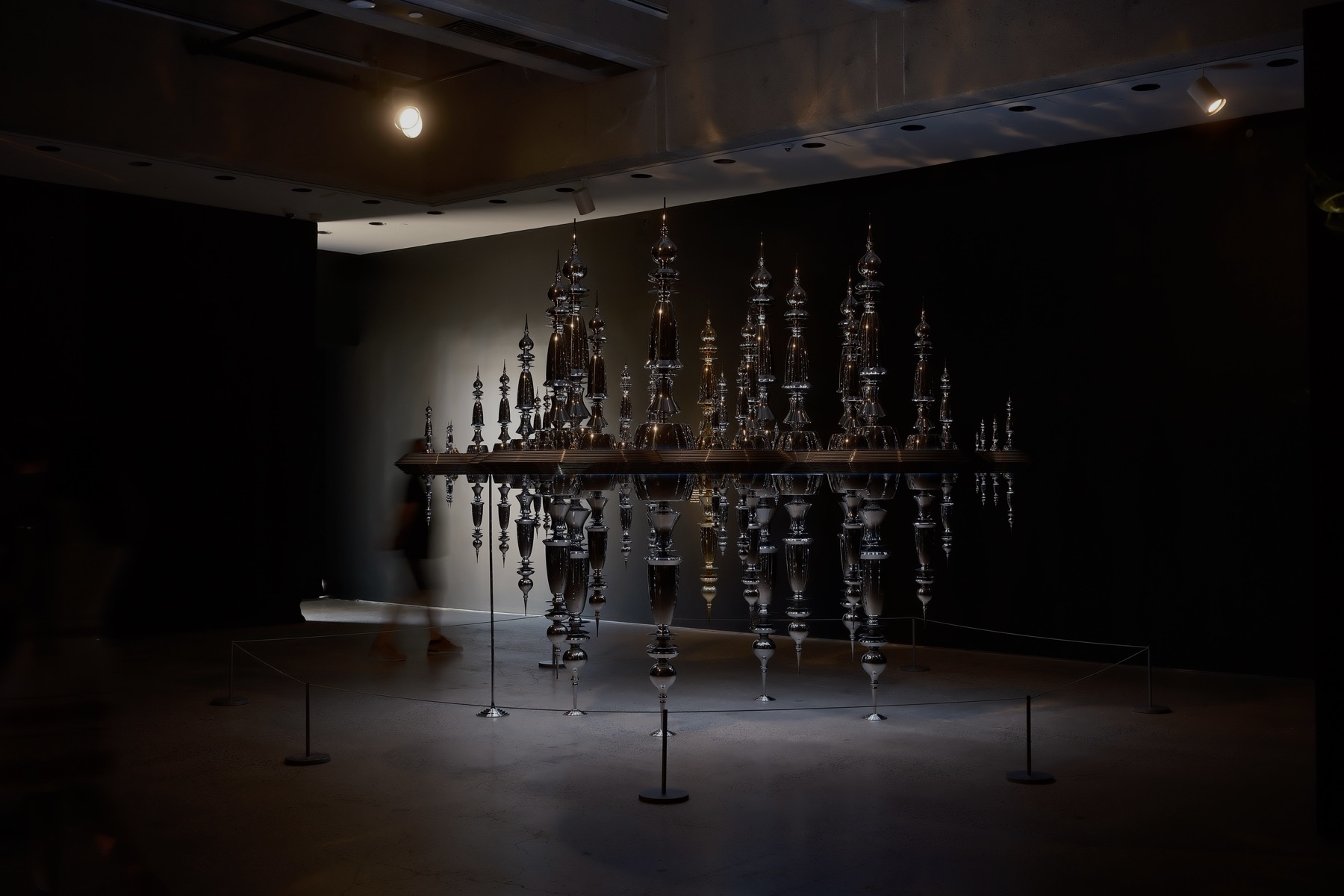 A mirrored city of silver spires hanging upside down in a dark room