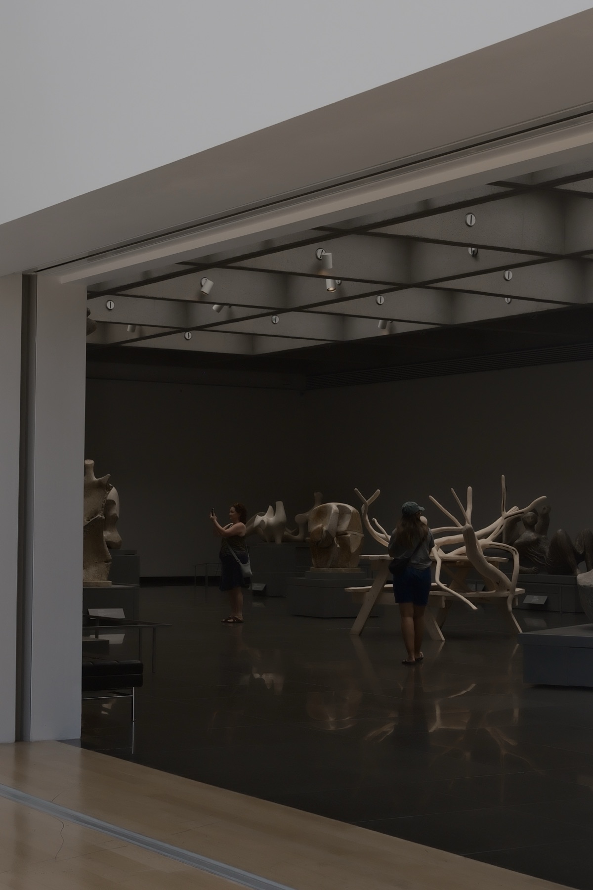 Moore's plaster figures at rest, two visitors photographing