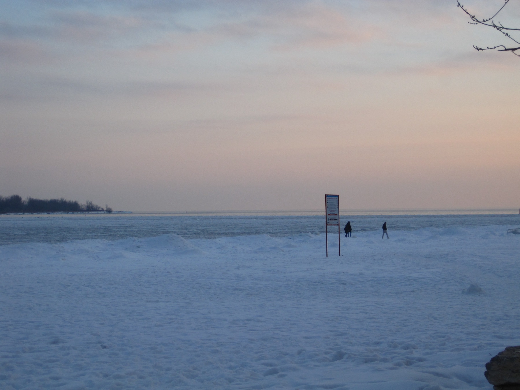 Two figures out on the frozen lake by a sign