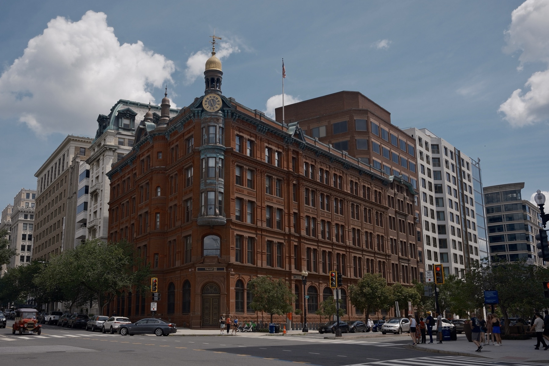A red brick corner building with a gold-domed clock