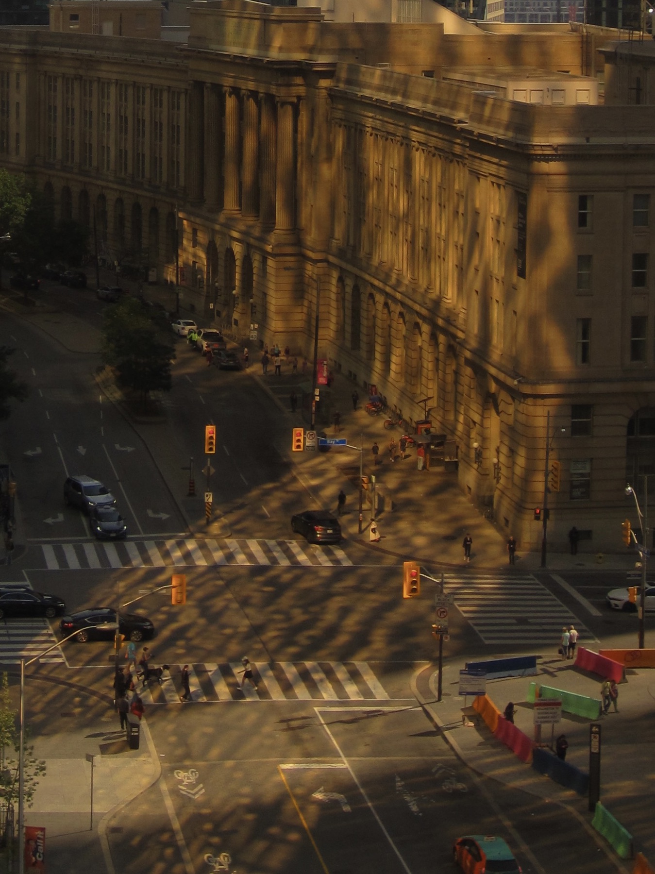 Stone columns glowing gold, long shadows thrown across the intersection