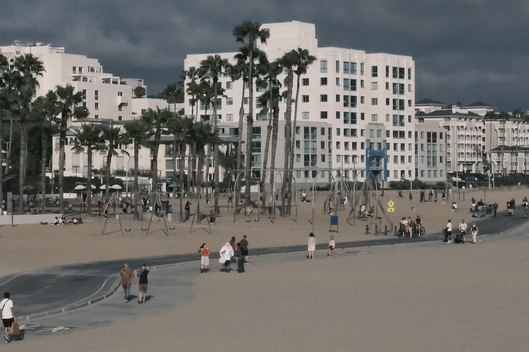 Swings on the sand before dark clouds