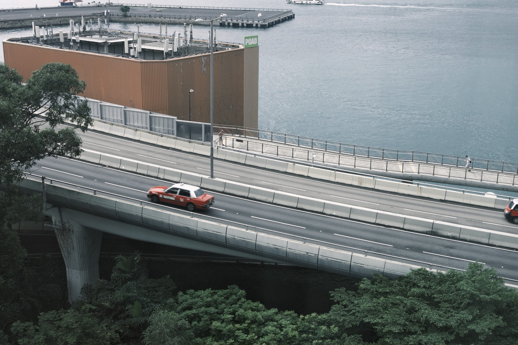 A red taxi on the flyover below the hotel window, the harbour beyond