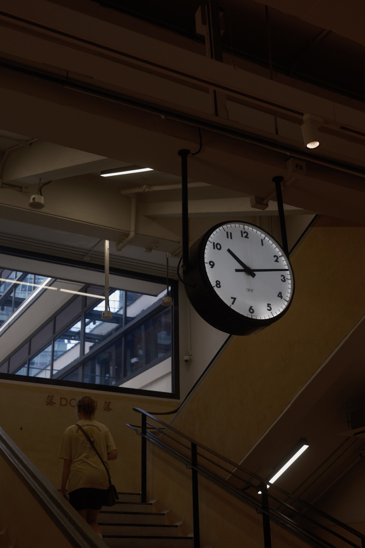An old double-faced clock hanging over the market stairs, reading 10:14