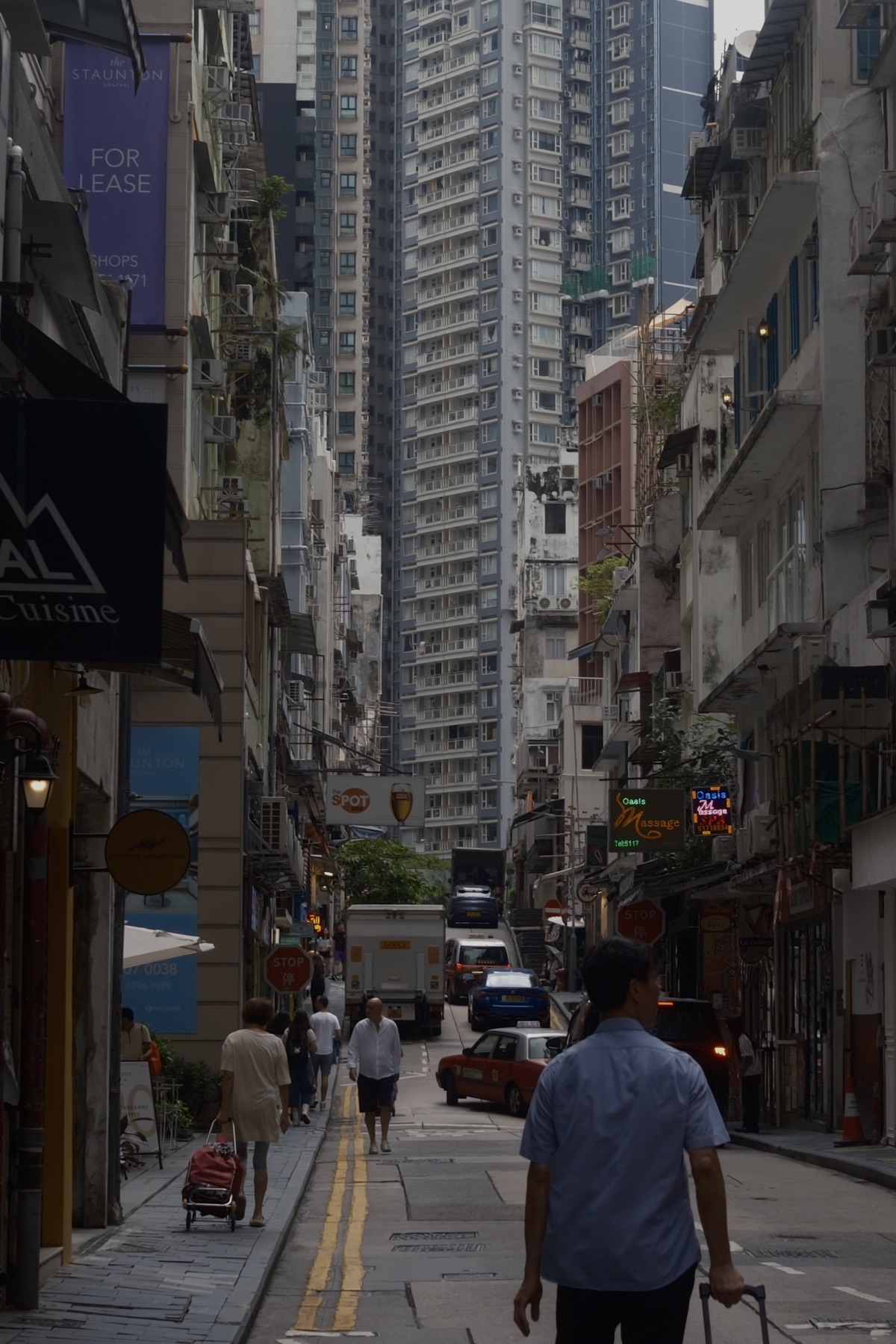 A climbing street of shophouses and towers stacked behind