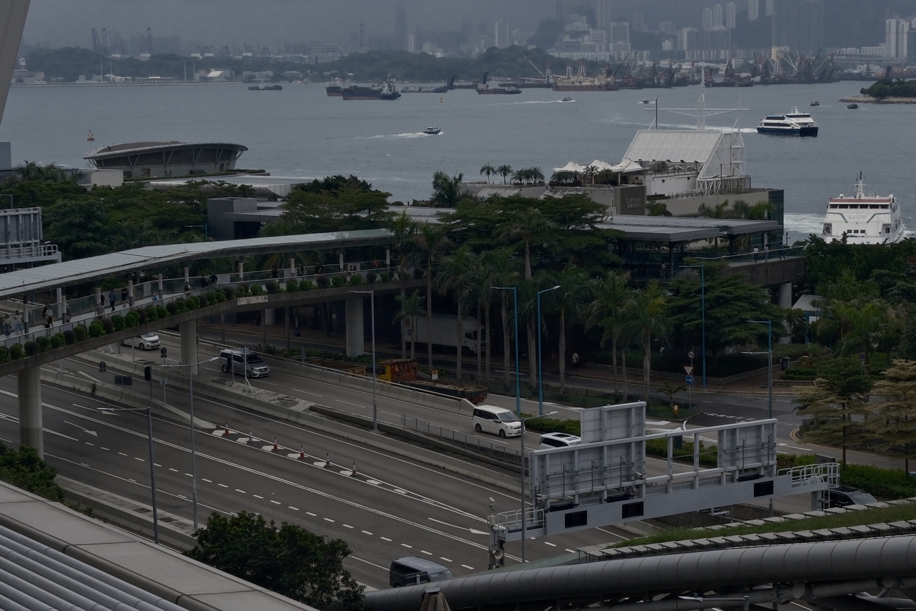 Walkway, road and harbour stacked in levels, ferries crossing