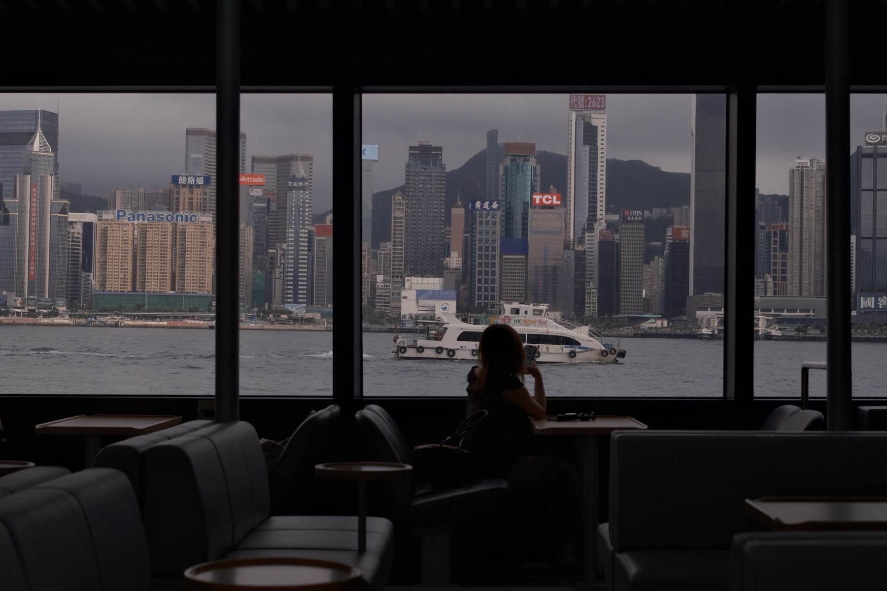 A girl at the ferry window, the island skyline filling the glass — A Borrowed Day
