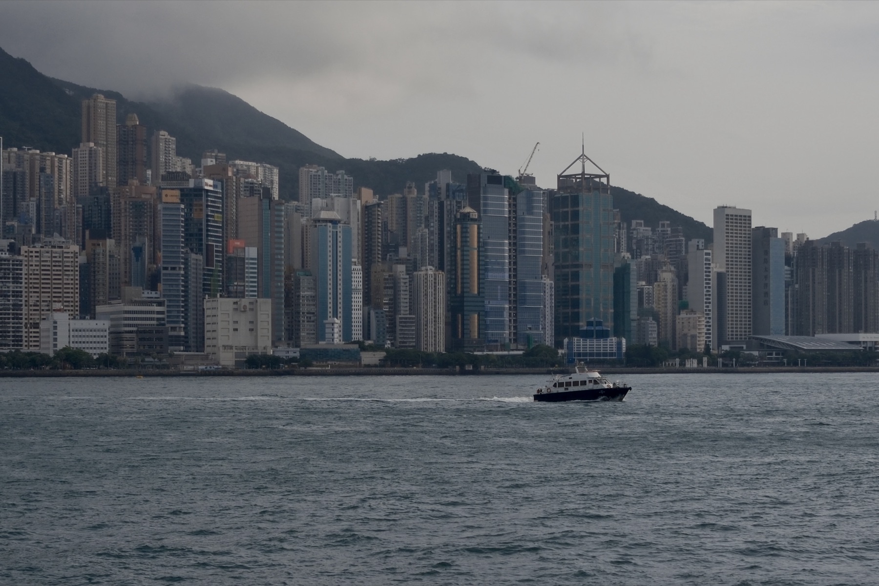The island gone grey-blue, the Peak under cloud