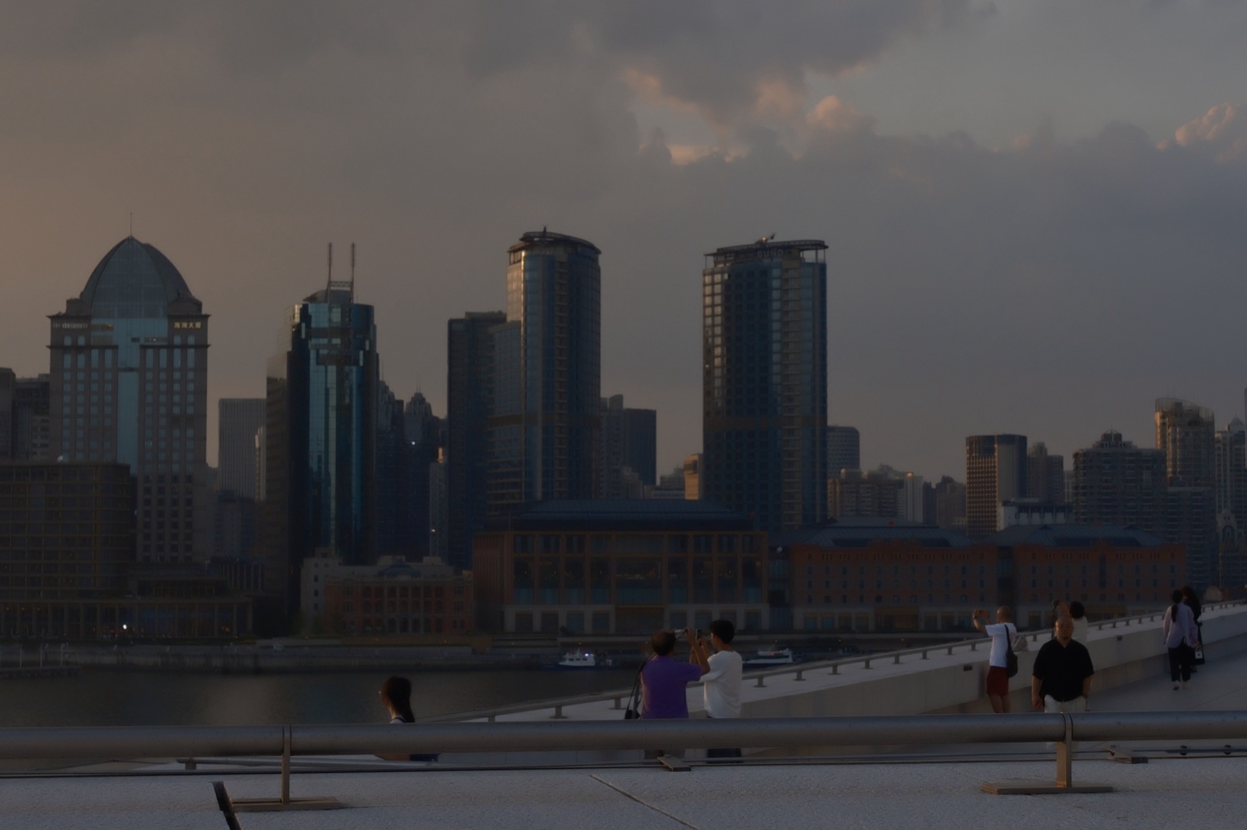Storm clouds over the Puxi towers, people photographing from the terrace