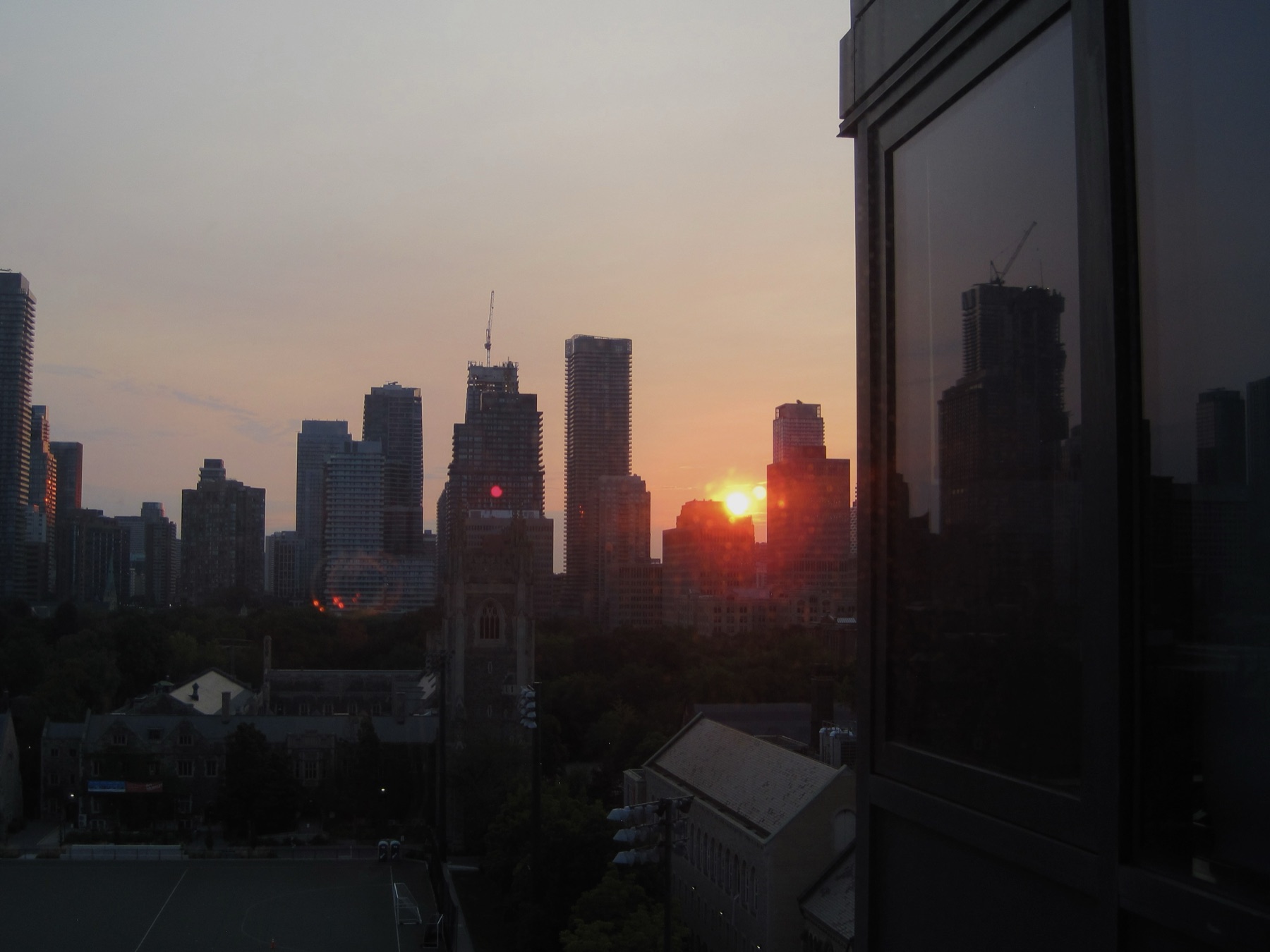 The sun rising in the gap between two downtown towers