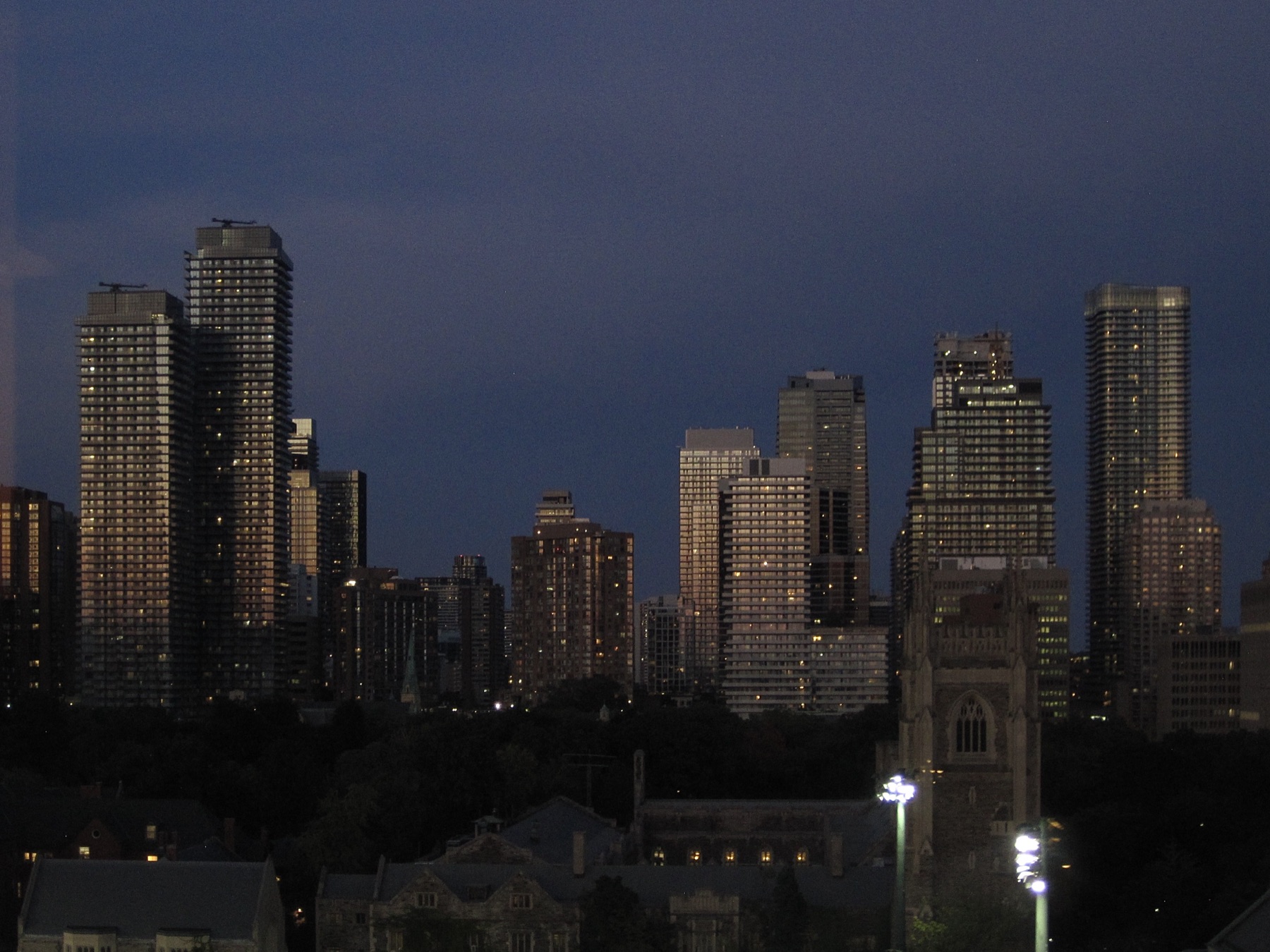 A dark stormy evening, lit tower windows and a floodlit field