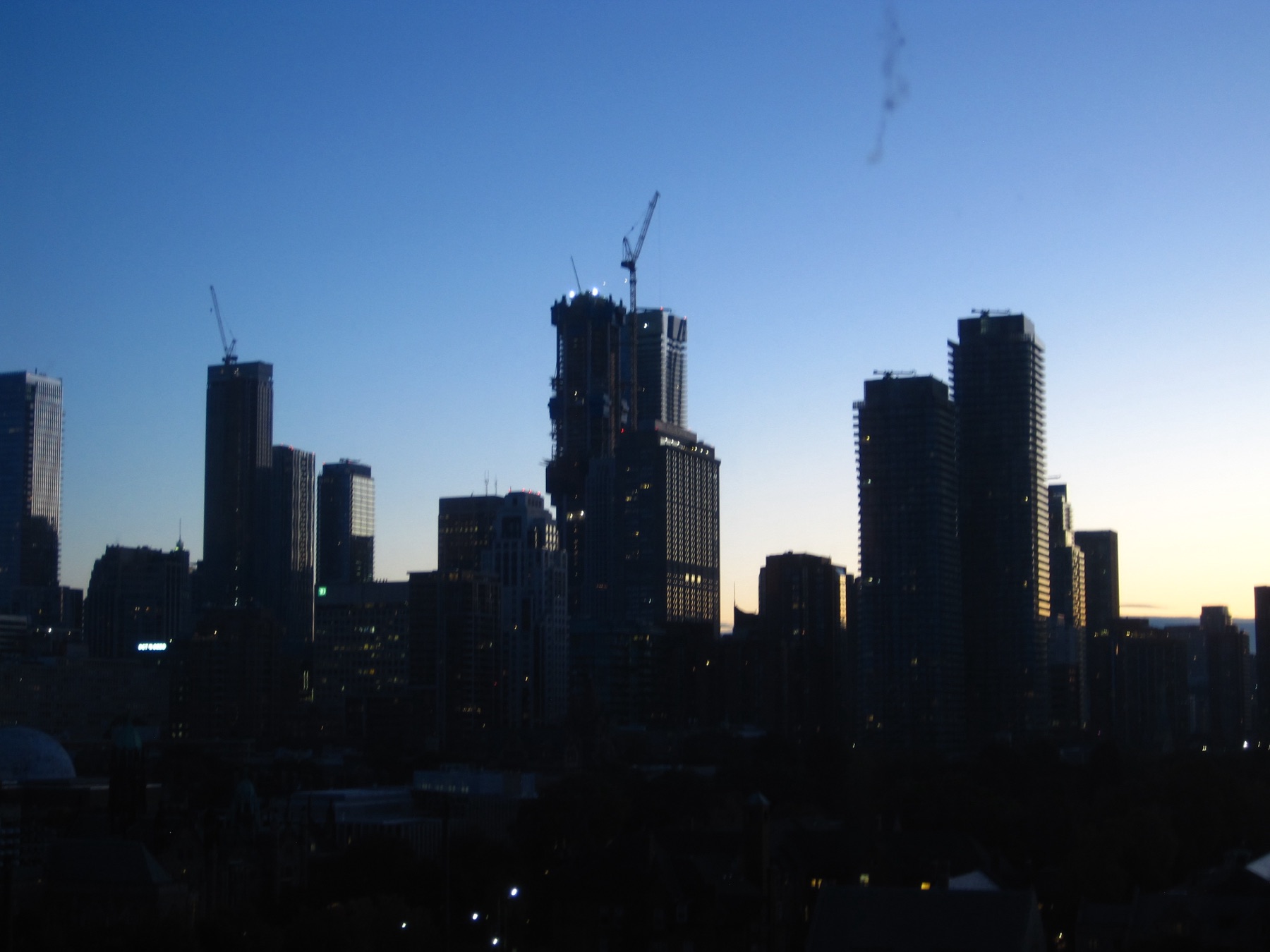 The skyline in silhouette against a clear deep-blue dawn