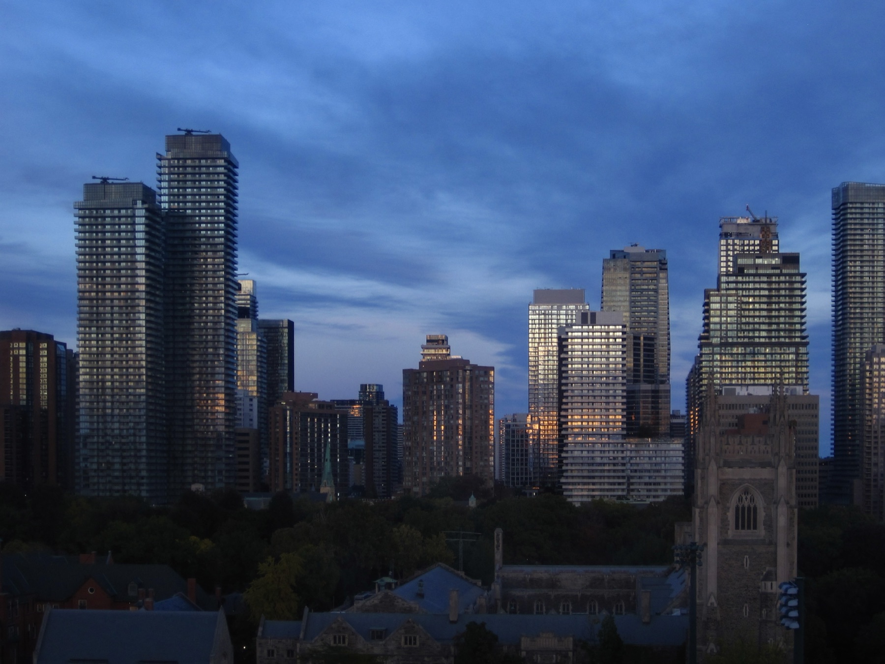 Streaky clouds over a blue dawn, a warm glow starting low
