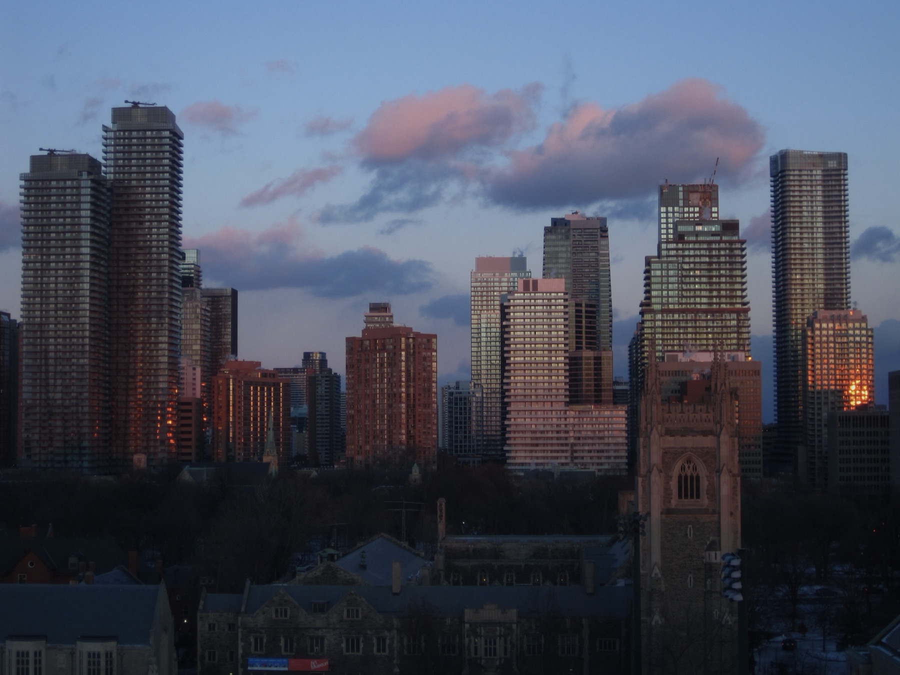 Pink winter sunset on the glass towers, snow on the rooftops
