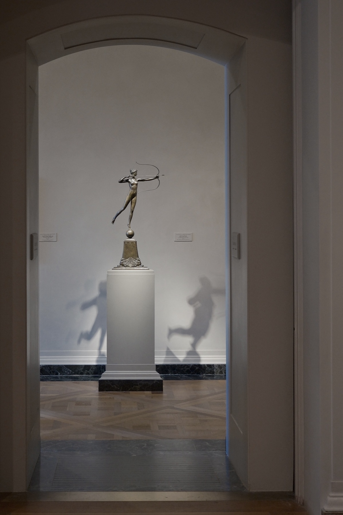 Diana balancing in a doorway, her shadow doubled