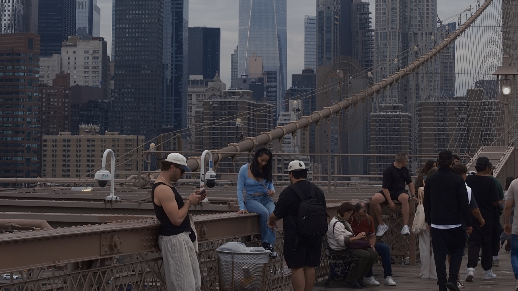 The crowded boardwalk of Brooklyn Bridge, One World Trade behind