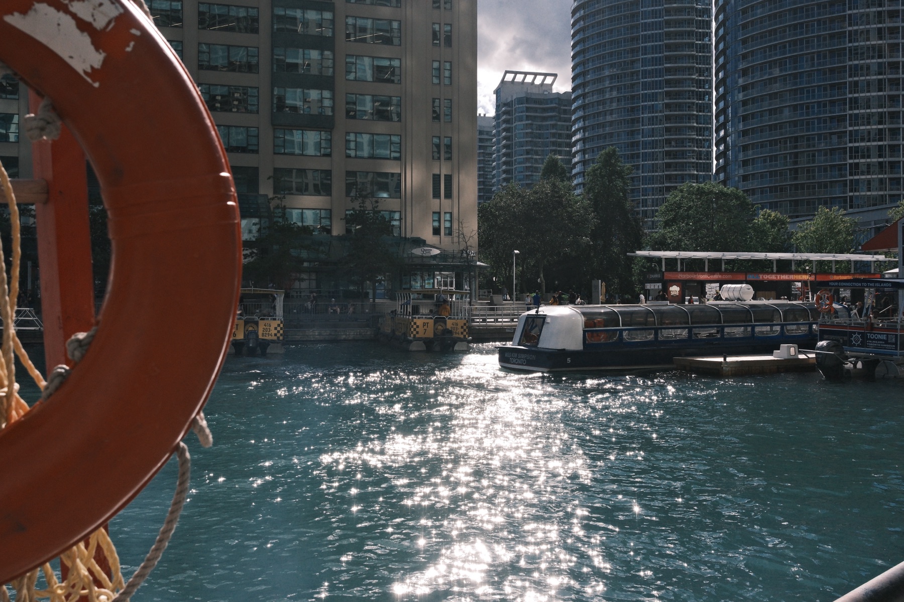 The ferry dock and downtown towers past an orange life ring