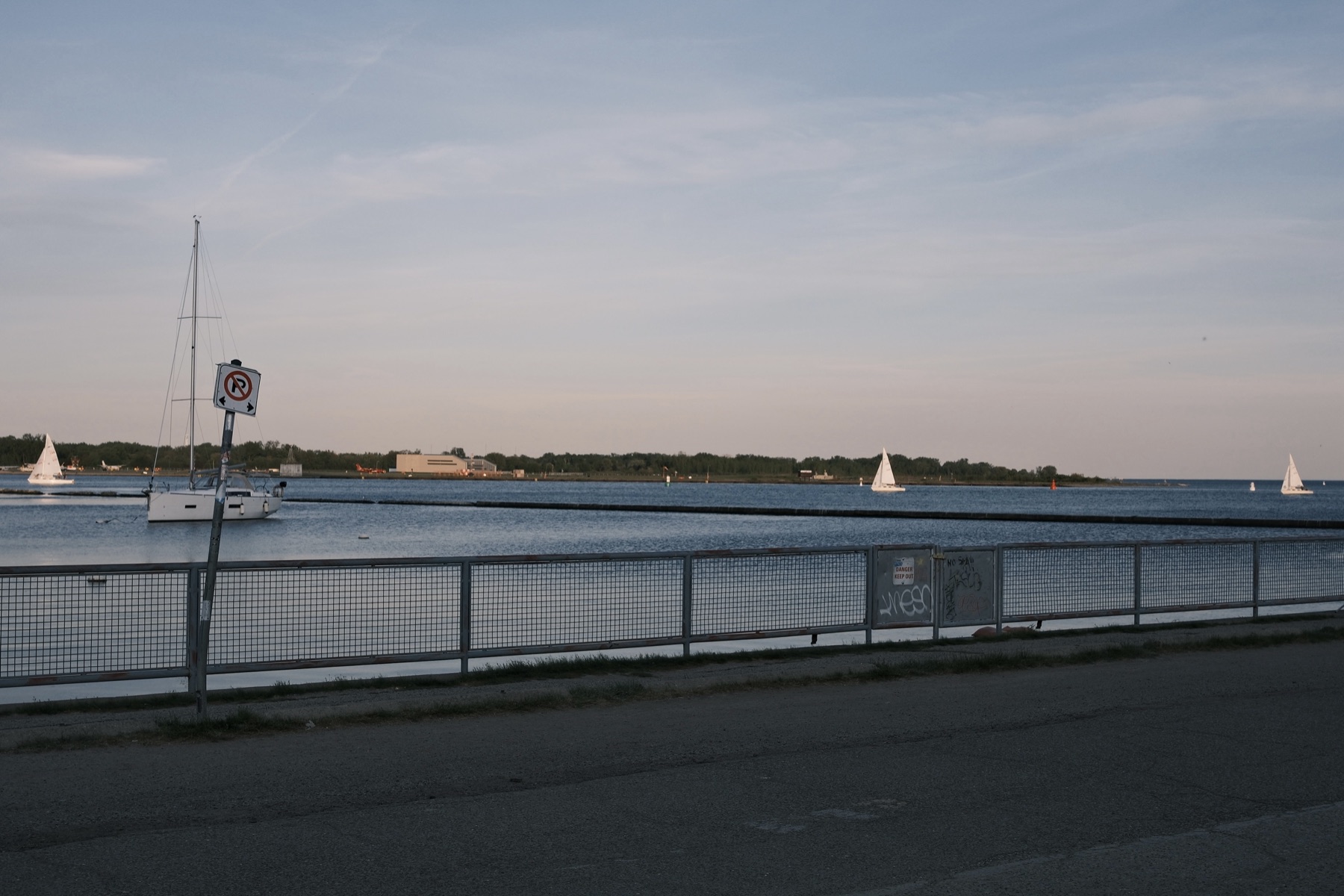 Sailboats on the lake seen over the trail railing