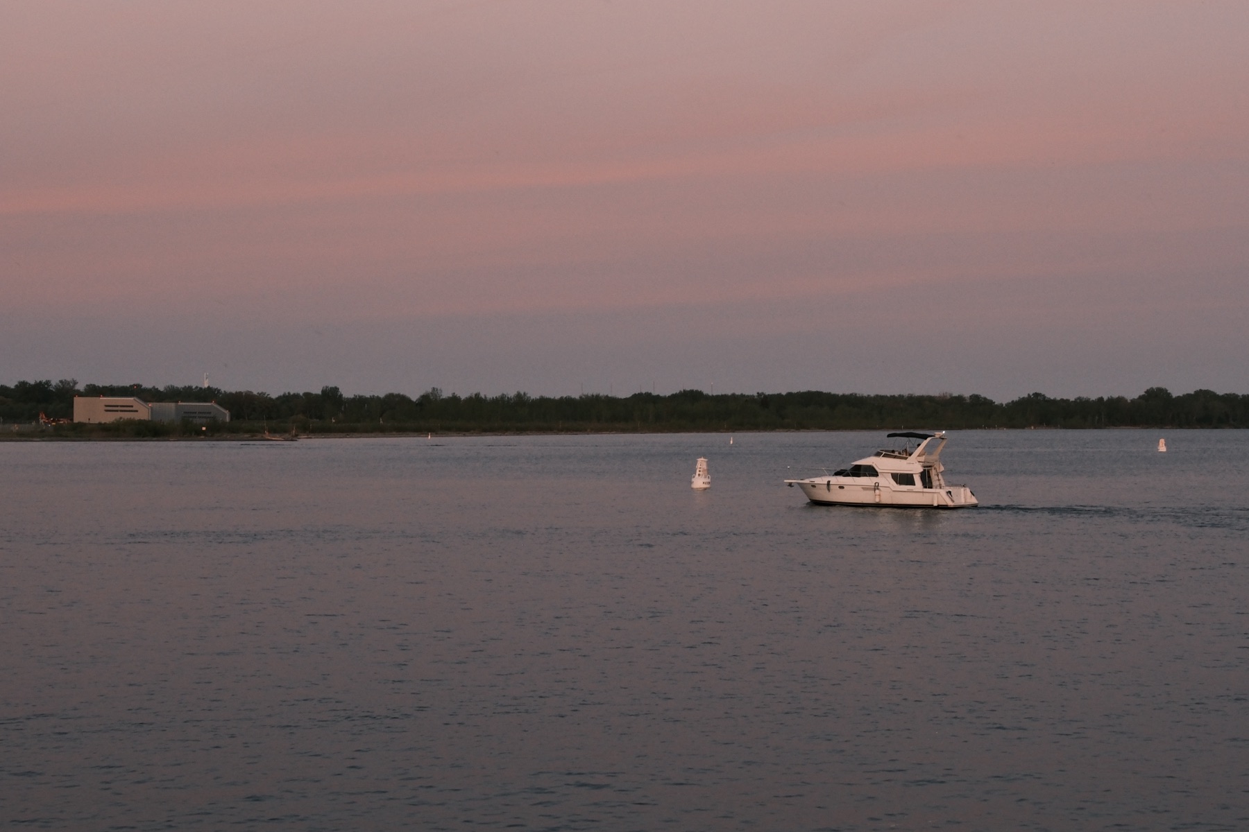 A white yacht on water gone entirely pink